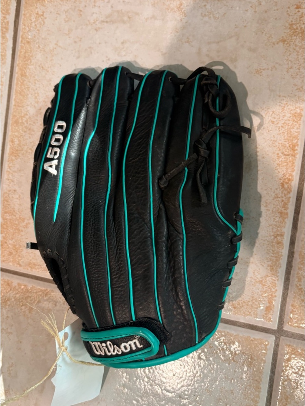 Women’s Wilson A500 Black softball Glove with Teal Piping. Left Handed